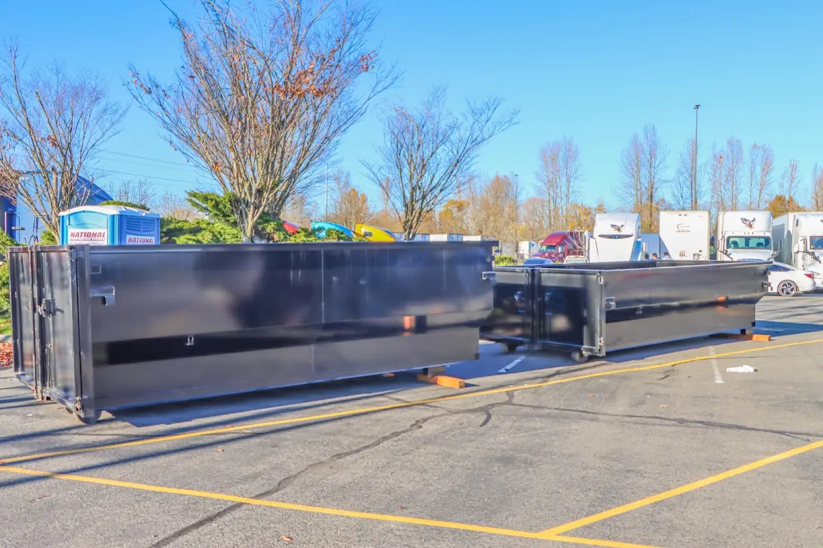 Professional dumpster rental service with roll-off container on residential driveway in Newark